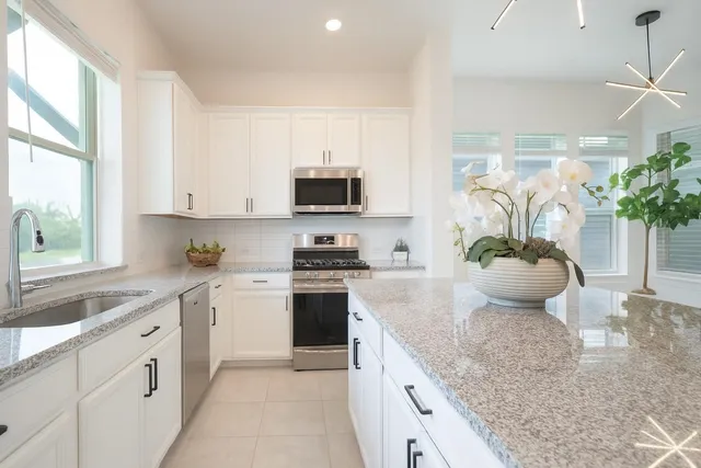 a kitchen with stainless steel appliances granite countertop a stove a sink and a granite counter tops