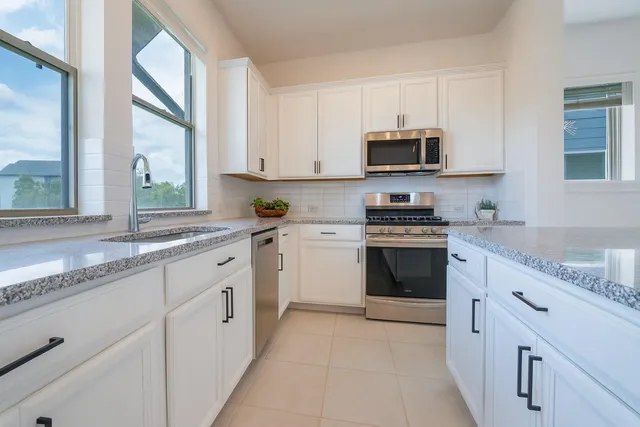 a kitchen with granite countertop white cabinets and white appliances