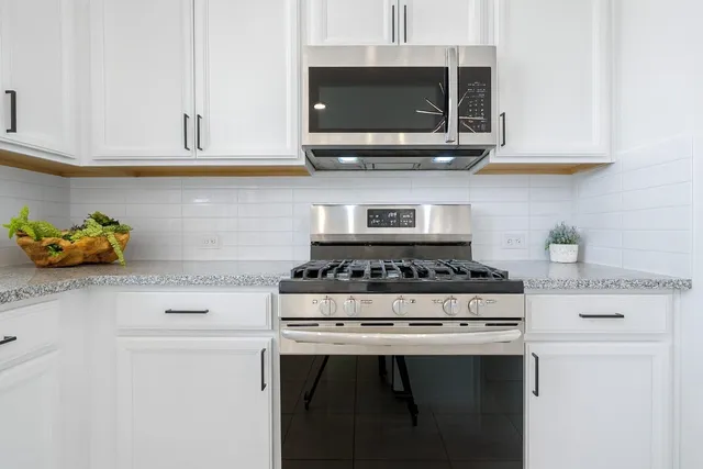 a kitchen with stainless steel appliances granite countertop a stove a microwave and cabinets