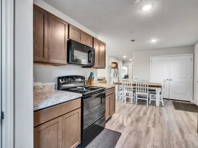 a kitchen with cabinets and wooden floor