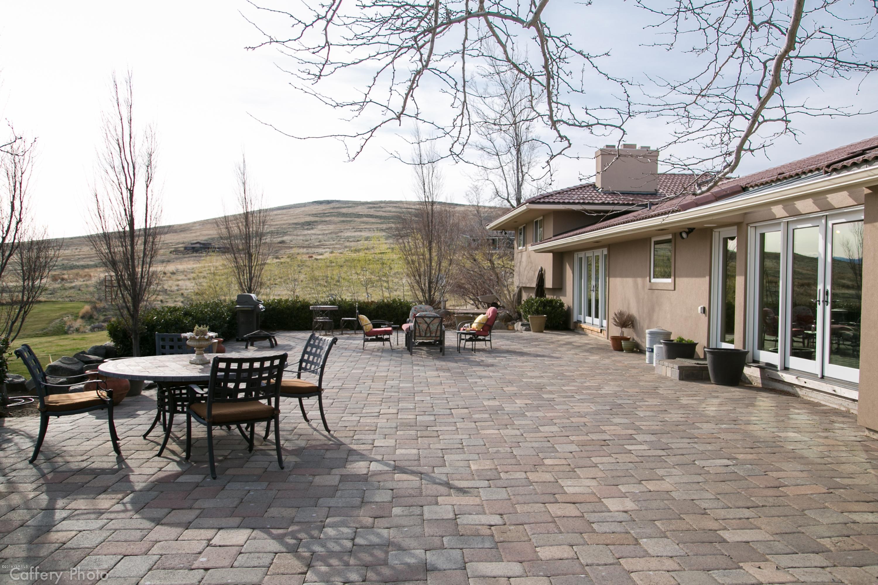 1102 Hillman Road Yakima, WA 98908 - Photo 22 of 49 a view of a patio with table and chairs and floor to ceiling window