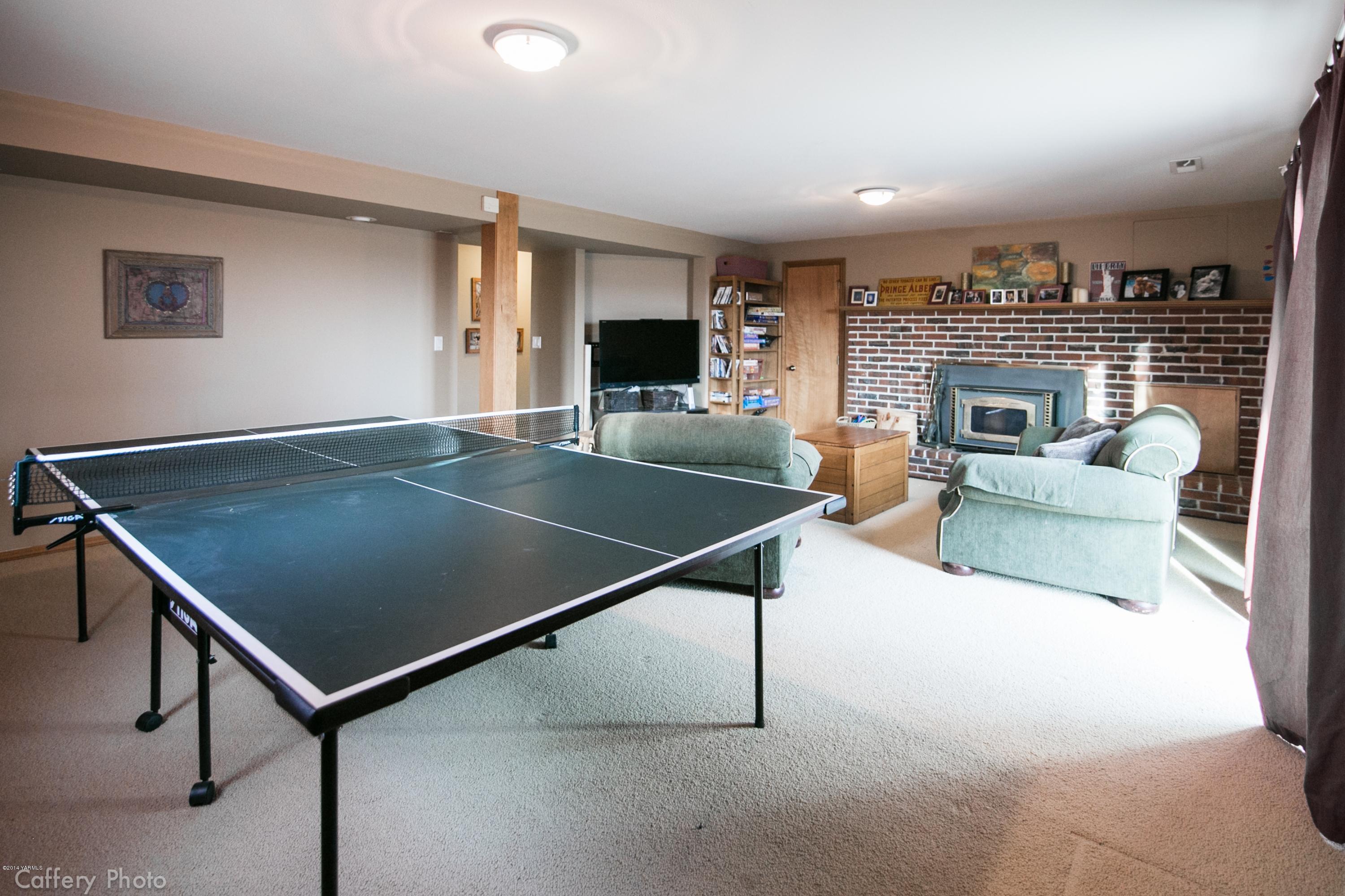 1102 Hillman Road Yakima, WA 98908 - Photo 42 of 49 a living room with pool table a fireplace and a flat screen tv