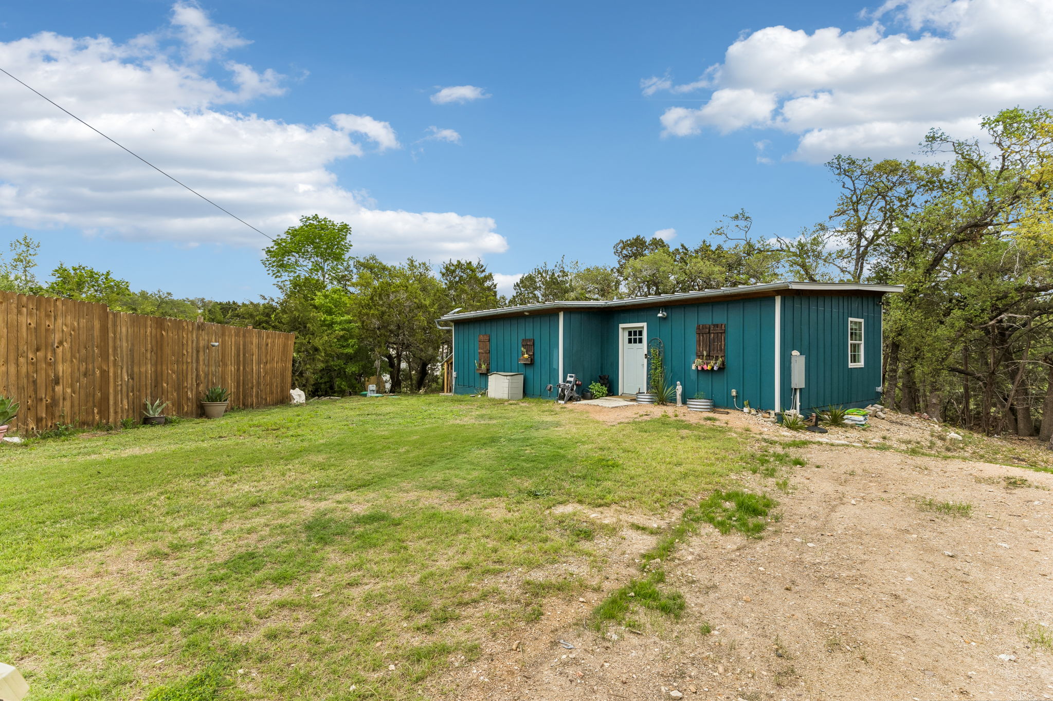 2240 Fm 3237 Road Wimberley, TX 78676 - Photo 4 of 26 This property features a vibrant teal exterior with a contrasting white door and windows