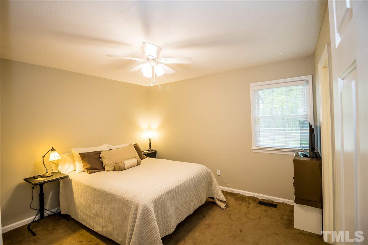 2009 Messer Road Raleigh, NC 27603 - Photo 21 of 30 a bedroom with a bed and a chandelier