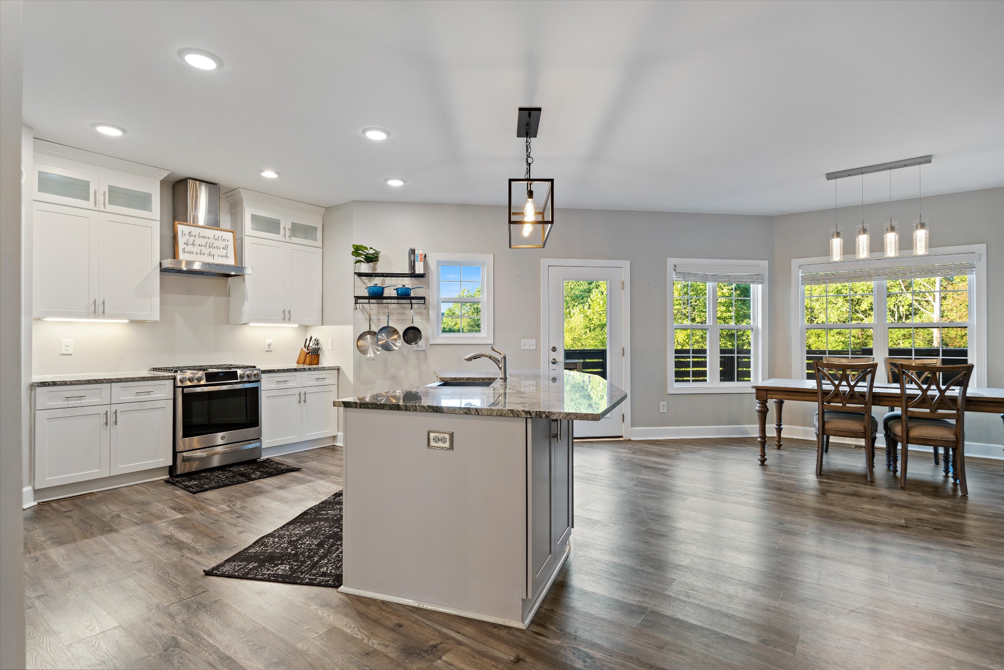 123 Chesapeake Court Lebanon, TN 37087 - Photo 19 of 62 a kitchen with stainless steel appliances kitchen island granite countertop a stove top oven a sink a dining table and chairs with wooden floor