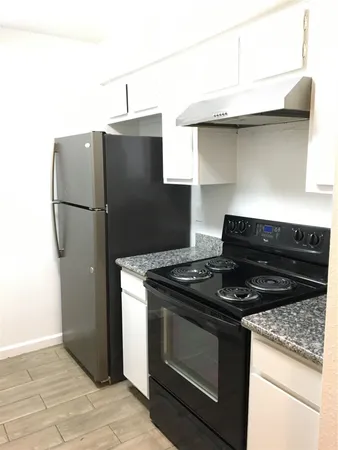 a kitchen with granite countertop a stove and a refrigerator