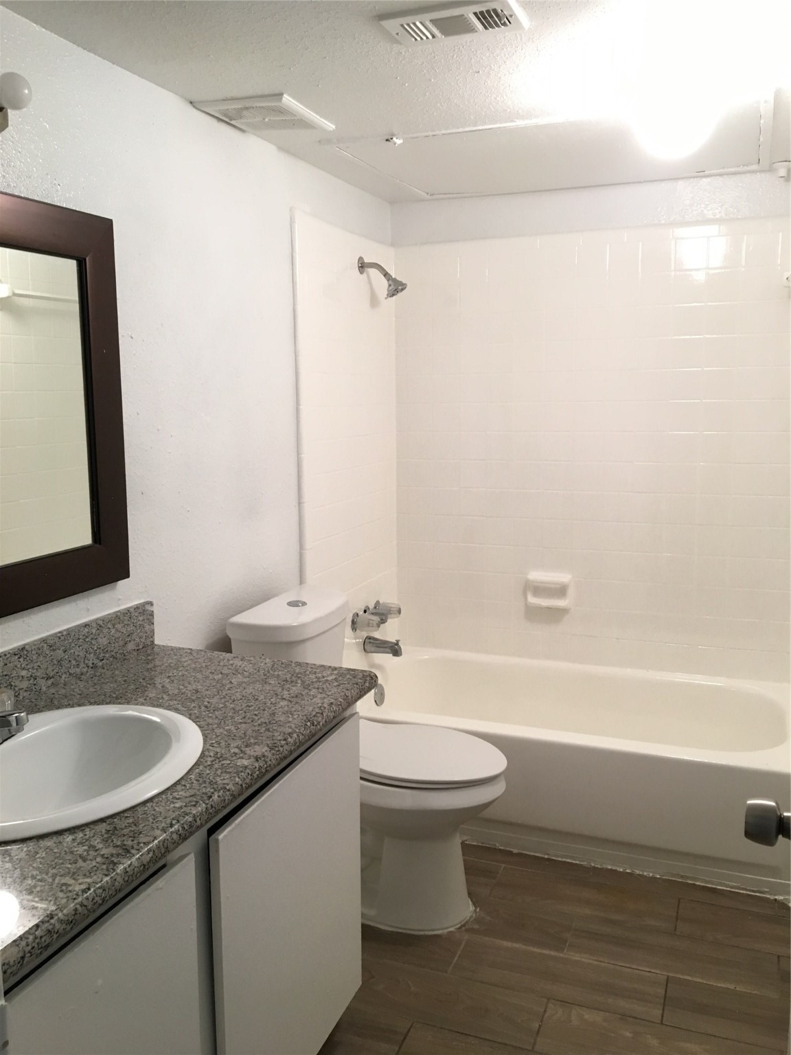 6200 West Tidwell Road, Unit 1615 Houston, TX 77092 - Photo 5 of 8 a bathroom with a granite countertop sink a toilet a mirror and bathtub