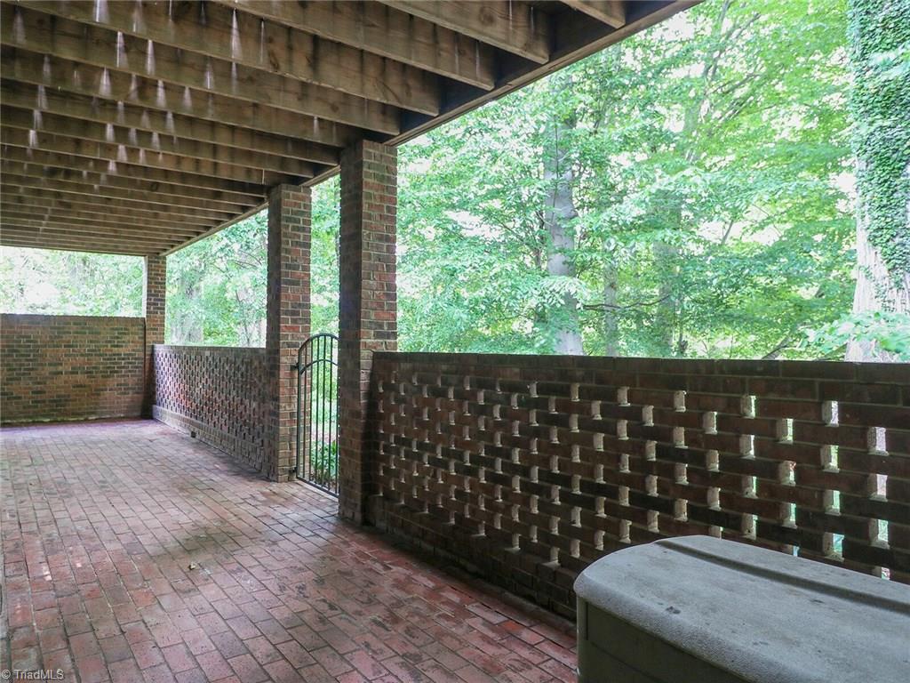 540 Lindley Road Greensboro, NC 27410 - Photo 28 of 29 Brick enclosed patio off the lower level den. Lots of privacy and great view of trees.