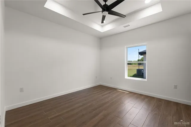 an empty room with a window and ceiling fan