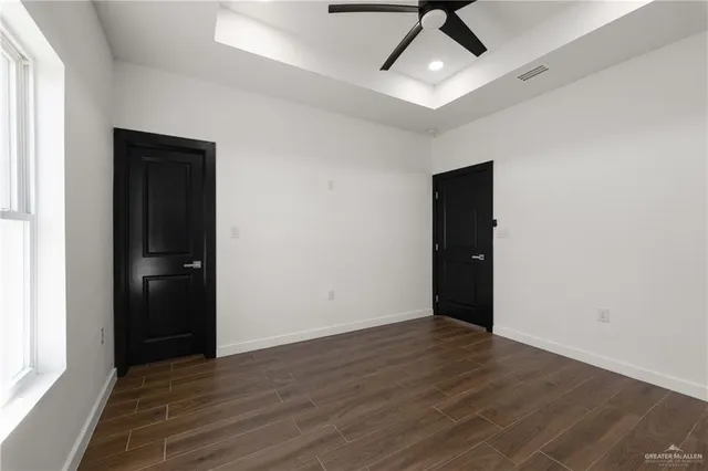 a view of an empty room with wooden floor