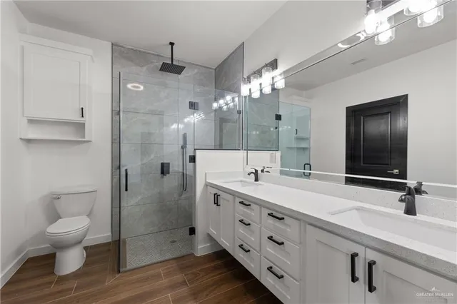 a bathroom with a double vanity sink mirror and toilet