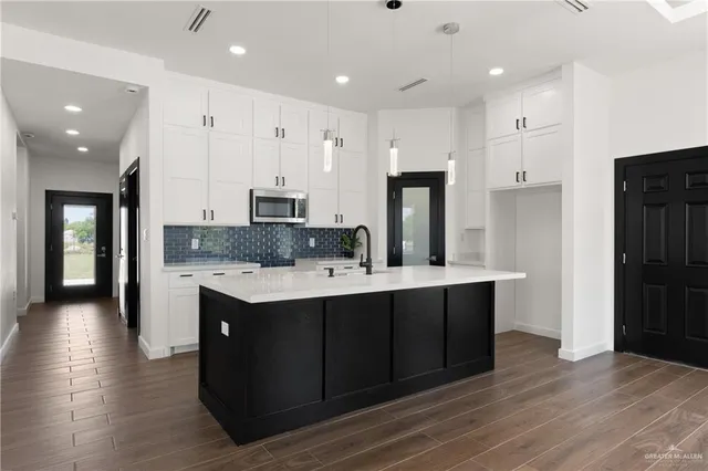 a kitchen with kitchen island wooden cabinets and refrigerator