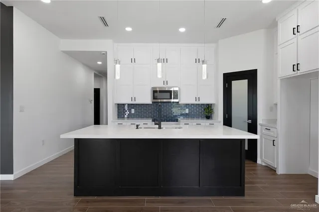 a view of kitchen island a sink wooden floor and kitchen view