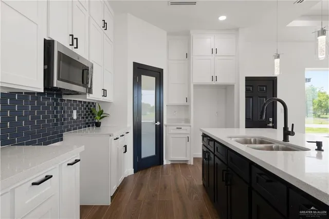 a kitchen with stainless steel appliances a sink and a refrigerator
