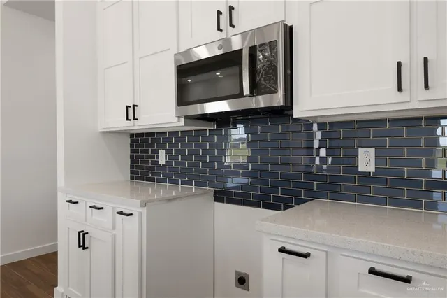 a kitchen with stainless steel appliances a sink a stove a microwave and cabinets