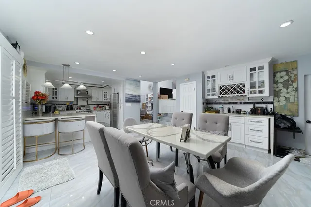 a kitchen with a dining table chairs and refrigerator