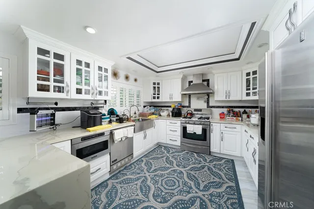 a kitchen with stainless steel appliances granite countertop a refrigerator and wooden cabinets