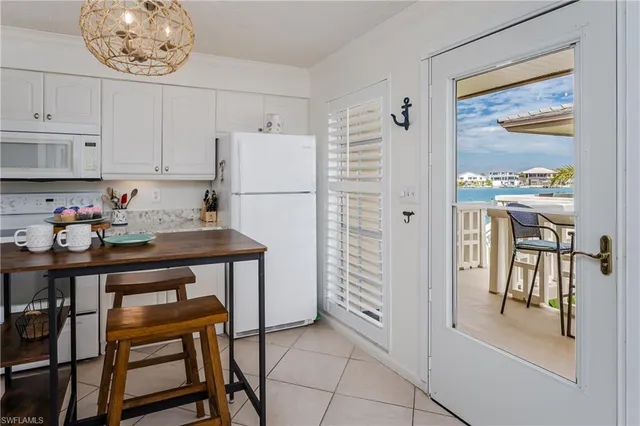 a kitchen with stainless steel appliances granite countertop a table chairs and a refrigerator