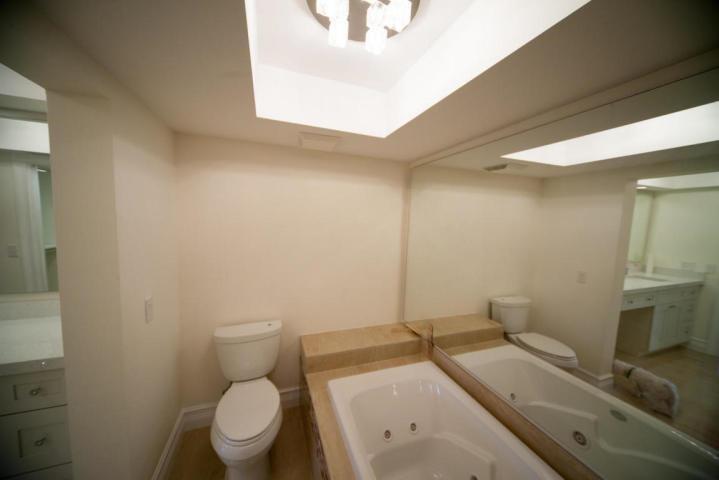 250 East Royal Palm Road, Unit 2A Boca Raton, FL 33432 - Photo 19 of 26 a bathroom with a granite countertop toilet sink and mirror