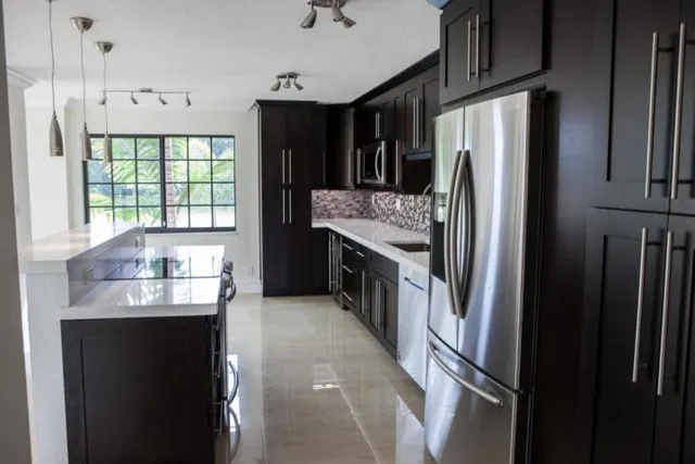 a kitchen with stainless steel appliances granite countertop a refrigerator and a sink