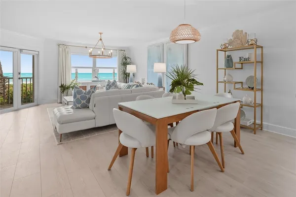 a dining room with furniture a chandelier and wooden floor