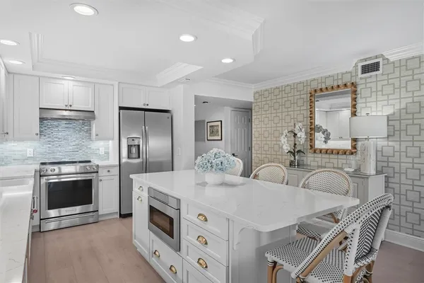 a kitchen with granite countertop a stove a sink and a refrigerator