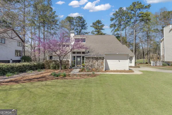 a view of a house with a yard and sitting area