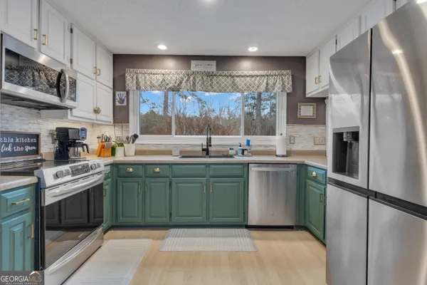 a kitchen with stainless steel appliances granite countertop a refrigerator and a sink
