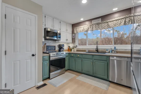 a kitchen with stainless steel appliances granite countertop a refrigerator and a sink