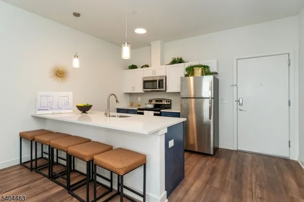a kitchen with kitchen island a refrigerator stove and microwave