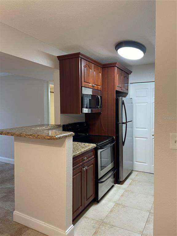 455 Alt 19, Unit 44 Palm Harbor, FL 34683 - Photo 3 of 22 a kitchen with stainless steel appliances granite countertop a stove a refrigerator and a sink