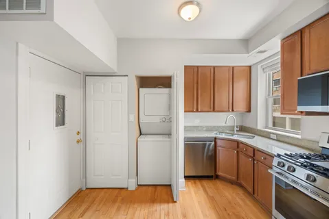 a kitchen with a sink cabinets stainless steel appliances and a window