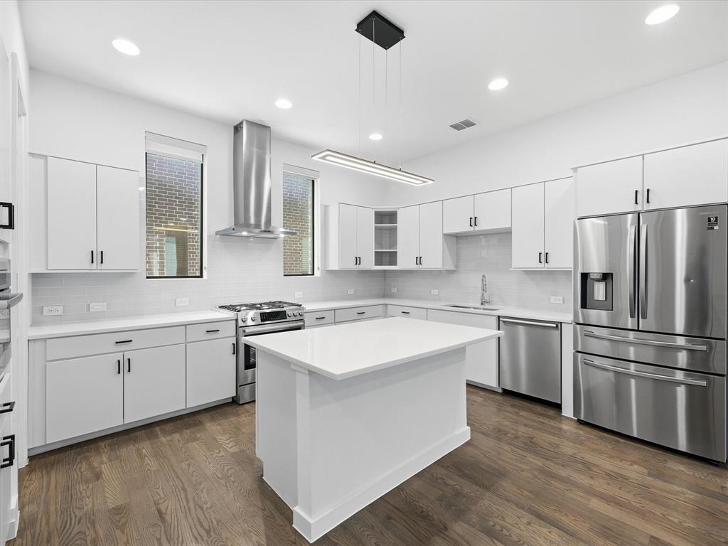 1920 Dowgate Court Dallas, TX 75204 - Photo 13 of 38 Kitchen with stainless steel appliances, white cabinets, dark wood-type flooring, decorative light fixtures, and glass insert cabinets