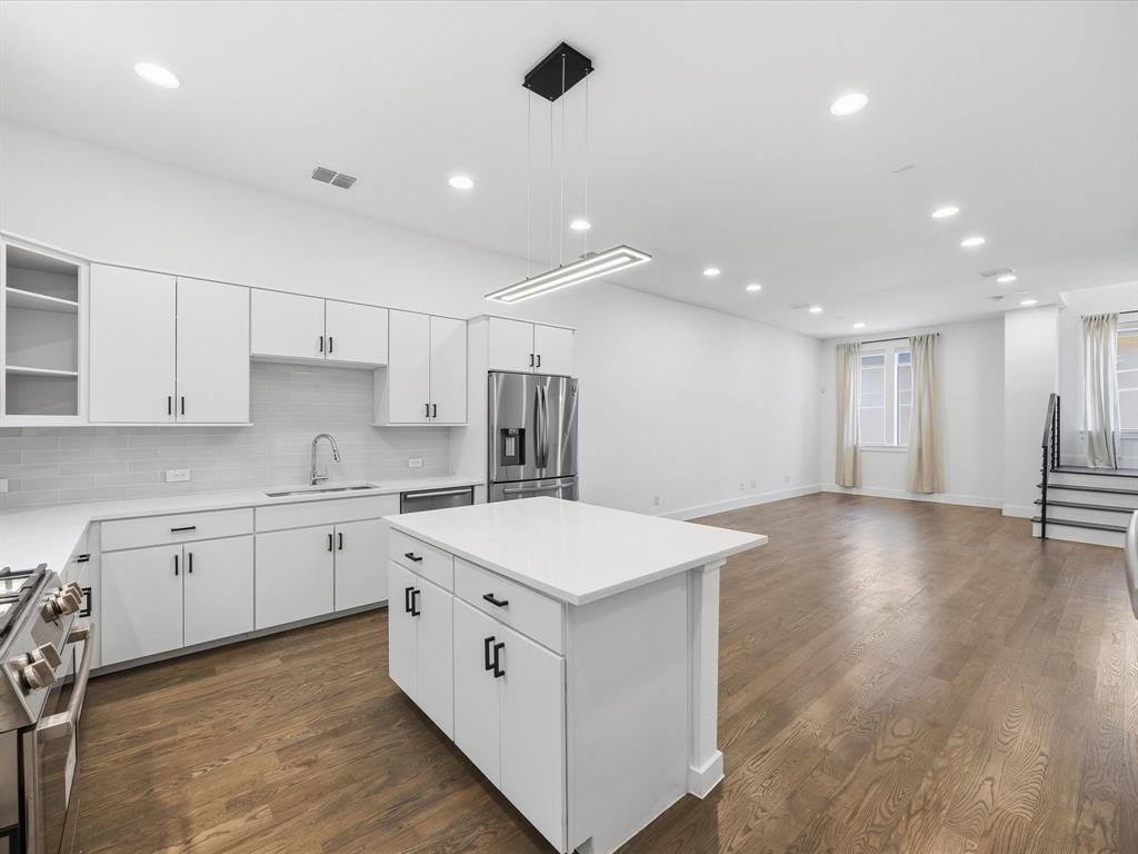 1920 Dowgate Court Dallas, TX 75204 - Photo 38 of 38 Kitchen with open floor plan, white cabinets, open shelves, stainless steel appliances, and pendant lighting