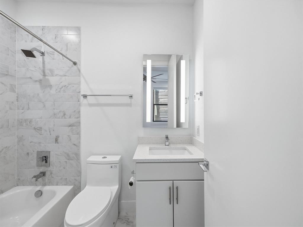 1920 Dowgate Court Dallas, TX 75204 - Photo 24 of 38 Bathroom with bathtub / shower combination, vanity, and marble finish flooring