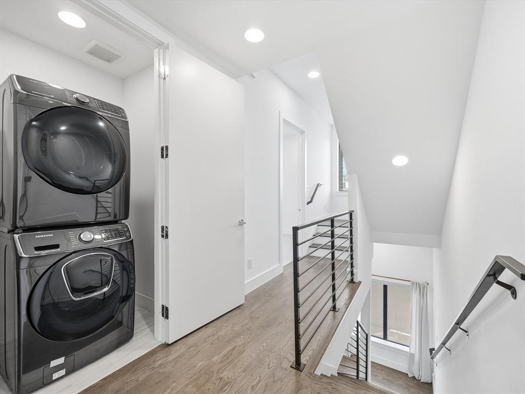 1920 Dowgate Court Dallas, TX 75204 - Photo 27 of 38 Laundry area featuring stacked washer / dryer, light wood finished floors, and recessed lighting