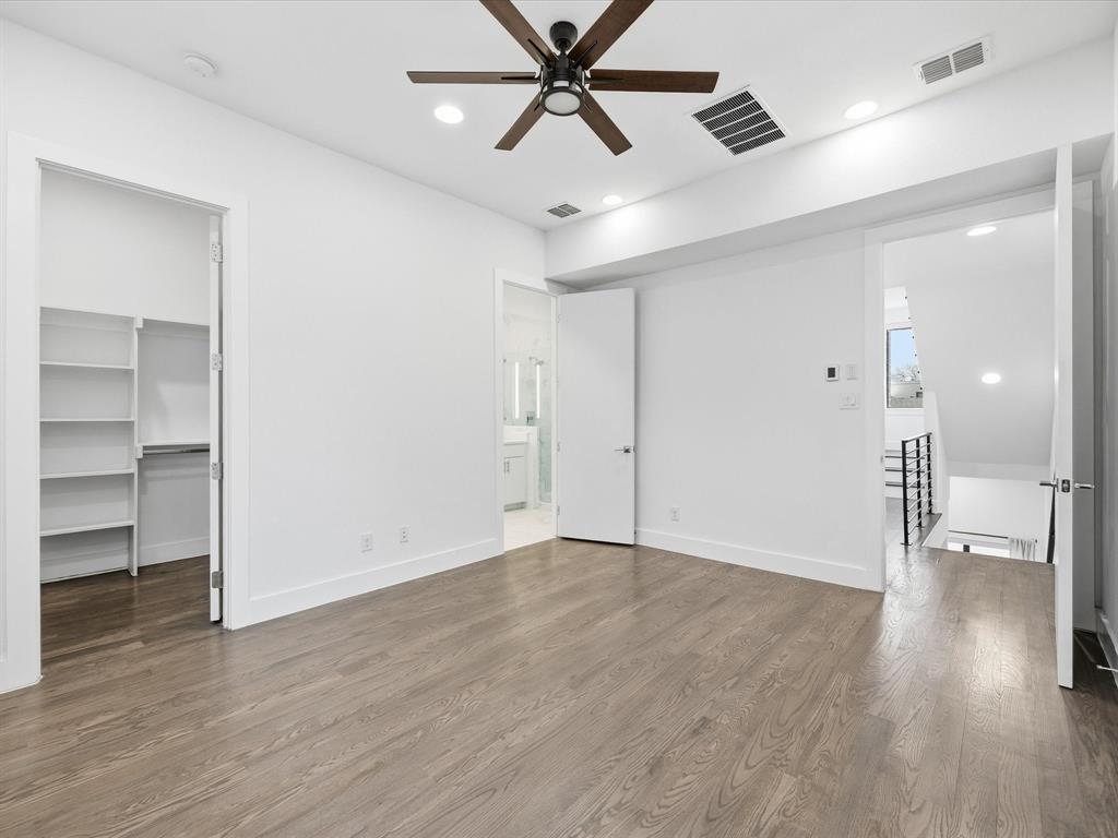 1920 Dowgate Court Dallas, TX 75204 - Photo 7 of 38 Unfurnished bedroom featuring a walk in closet, wood finished floors, recessed lighting, and a ceiling fan