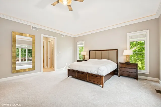 a spacious bedroom with a bed lamp and a large window