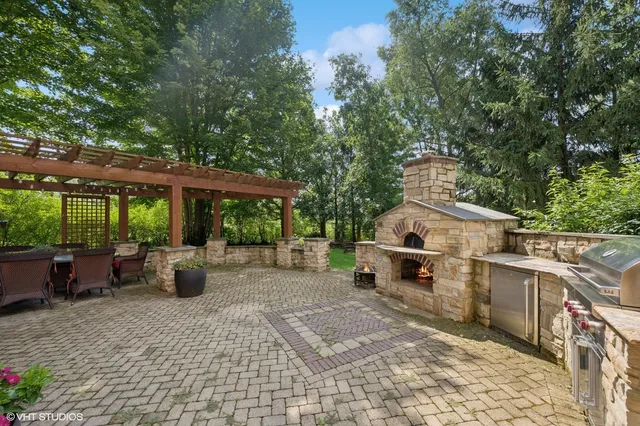 a view of a patio with table and chairs potted plants and large tree