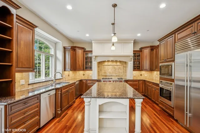 a kitchen with lots of counter top space a sink appliances and cabinets