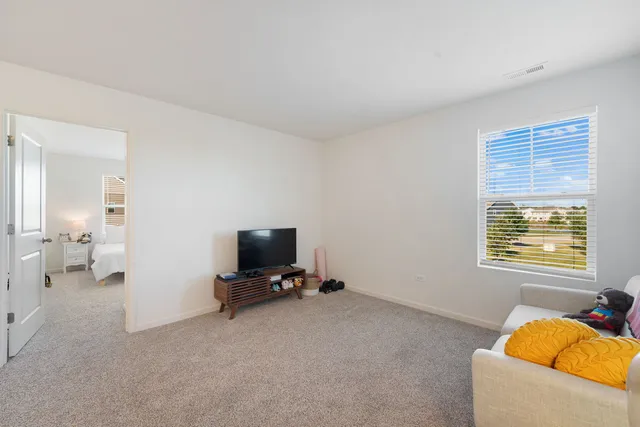 a view of an empty room with a window and a flat screen tv