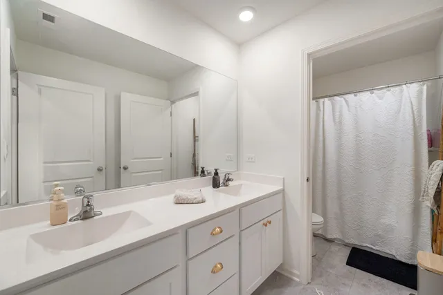 a bathroom with double vanity sink and a mirror