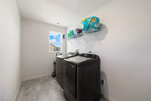 a utility room with a sink a mirror and window