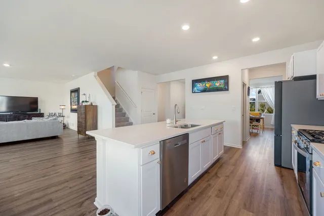 a large kitchen with a lot of counter space and wooden floor
