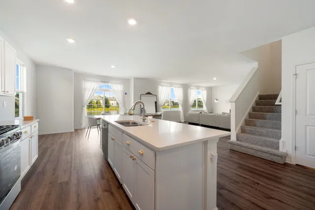 a kitchen with counter top space sink and wooden floor