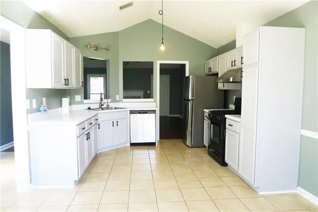 a kitchen with a sink counter top space cabinets and stainless steel appliances