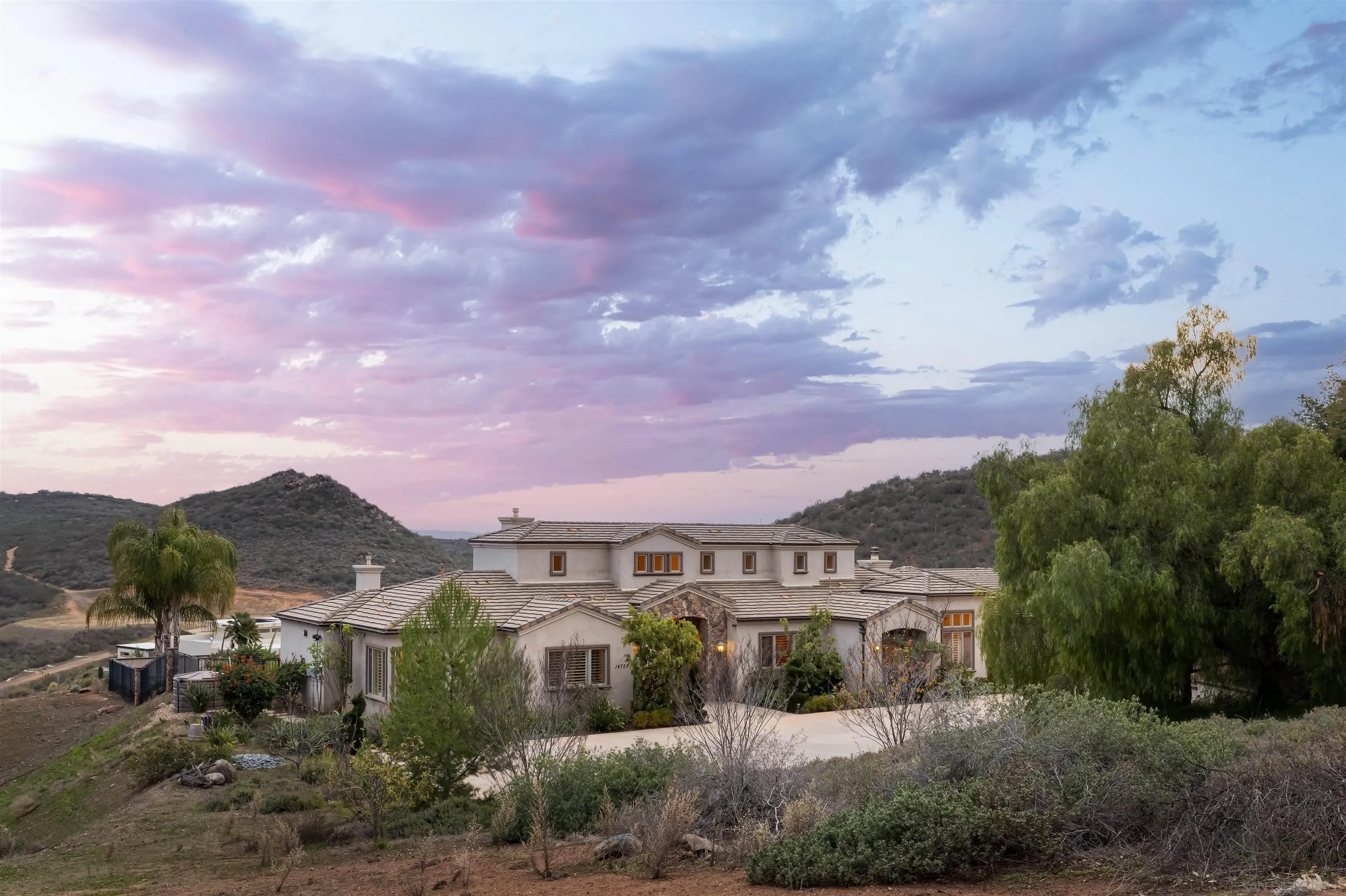 14755 High Valley Road Poway, CA 92064 - Photo 44 of 59 a front view of a house with a yard and mountain view in back