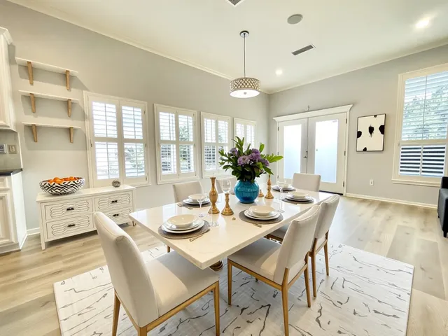 a view of a dining room and livingroom with furniture wooden floor a chandelier