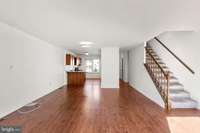 a view of a kitchen with wooden floor and stairs