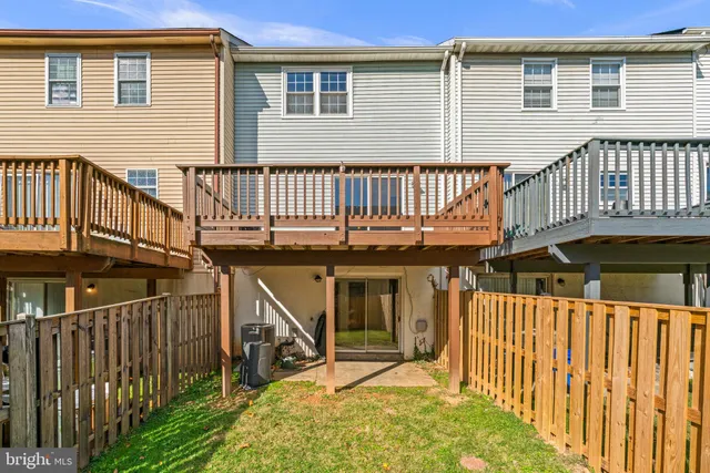 a view of a house with wooden deck front of house